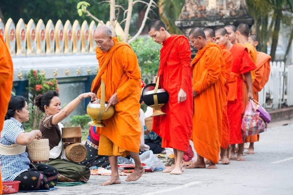 Giving offering to monks in Thailand